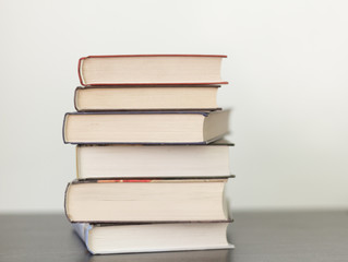 a stack of different books in a thick cover on the table