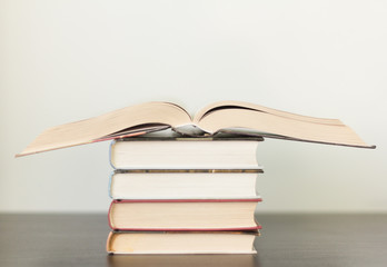 open book on a stack of books on the table, many books