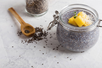 Mango chia dessert with plant milk in glass jar, vegan snack or dessert