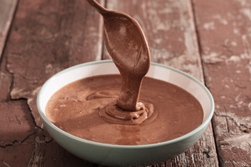chocolate dough in plate on old wooden table