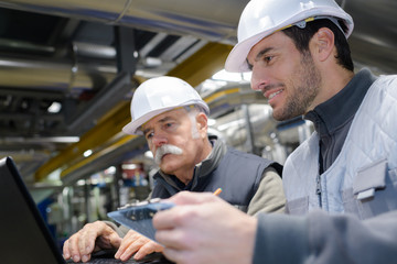 factory engineers looking at laptop