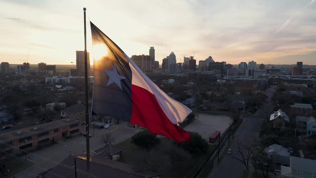 4K Texas Flag Aerial at Sunset with Downtown Austin in Back