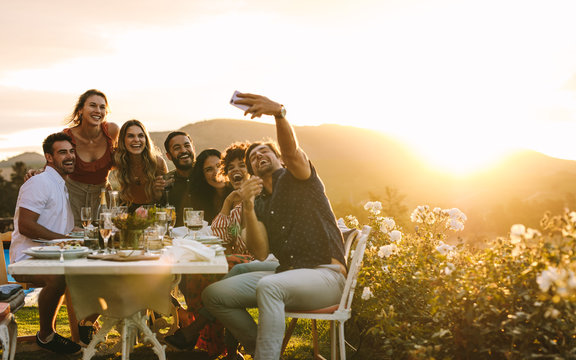 Friends chilling at dinner party taking selfie