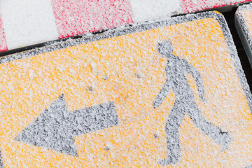 Yellow road sign with snow