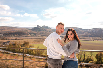 Romantic young couple hugging and smiling outdoors.