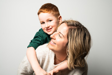A happy young mother with a child on light grey background