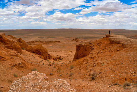 Man standing in desert taking a photo, Flaming Cliffs, Gobi Desert, Bulgan, Mongolia