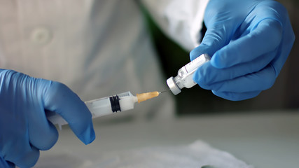 Doctor prepares injection syringe