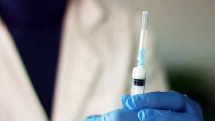 Professional nurse prepares syringe for vaccine
