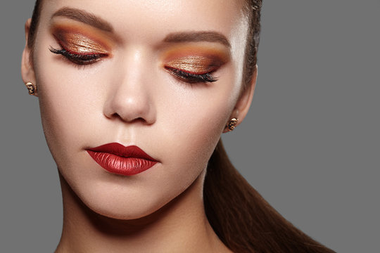 Beautiful Woman With Professional Makeup. Party Gold Eye Make-up, Perfect Eyebrows, Shine Skin. Bright Fashion Look