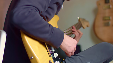 Guitarist plays yellow electric guitar in slow motion