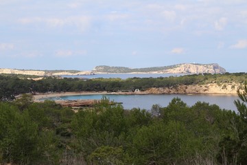 Cala Bassa Beach on Ibiza with mountains and oceans in the background