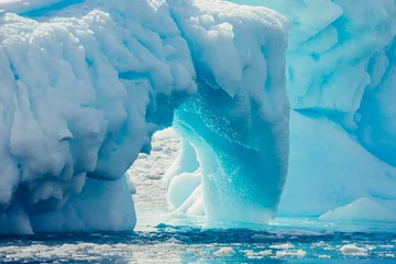 Foto auf Acrylglas Gletscher Close-up-Bogen des Eisbergs. Antarktische Landschaft in den Blau- und Weißtönen. Überwältigende Szene des eisbedeckten Gletschers, der im Polarozean schwimmt. Die geometrischen Formen des Eisbergs.