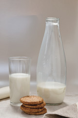 bicchiere latte con biscotti e bottiglia latte fronte