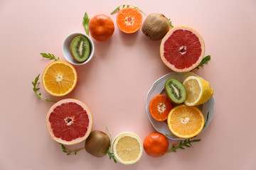 Tropical fruits frame from orange, lemon, tangerine and kiwi on pink paper background. Healthy food concept. flat lay. Top view