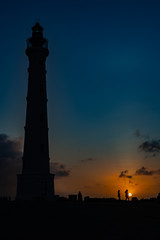Fototapeta na wymiar Aruba ,California Lighthouse and people in silhouette at sunrise
