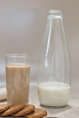 bicchiere caffè e latte con biscotti e bottiglia latte fronte