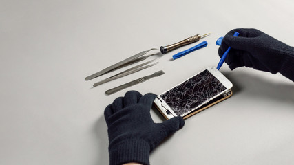 Technician or engineer opening broken smartphone for repair or replace new part on desk with copy...