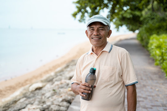 Male Senior Asian Smiling With Water Bottle