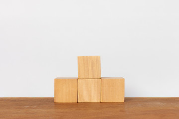 Wooden cube stack a pyramid staircase on white background. Concept of success, winner, victory or top ranking