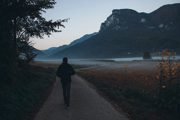 Man Walk by Empty Road in Misty Morning Mountains