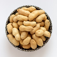 Raw peanuts in shell on clay cup. Top view	