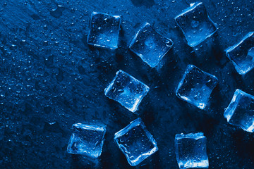Pieces of ice cubes with water droops on black background.