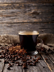 Coffee with coffee beans and spices on the wooden  background.