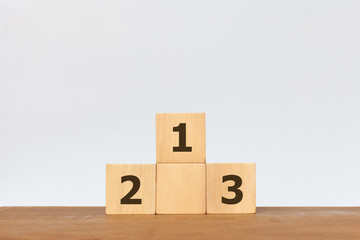 Hand arranging wooden cube with the number 1 2 3 on white background. Concept of success, winner, victory or top ranking