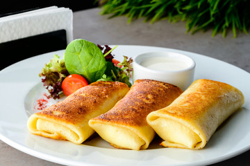 Appetizing pancakes (blinis) with sour cream on the table. New menu for the restaurant