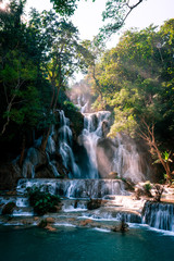 Naklejka premium Amazing Kuang Si Falls in Luang Prabang, Laos. Perfect blue water combined with beautiful sunlight and powerful green colors.