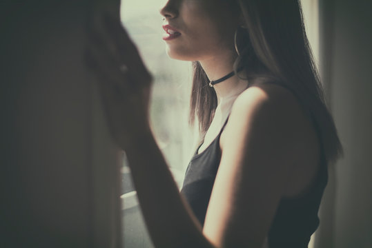Teenage girl looking through a window