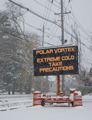 Road sign in snow warning of polar vortex
