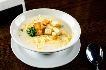 Cheese soup. Delicious soup with cheese and croutons in the white bowl in a restaurant