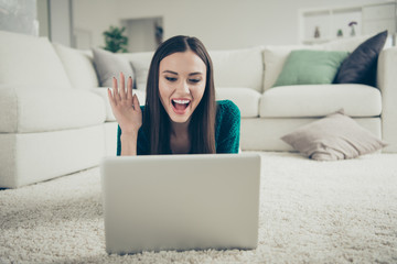 Remote communication concept. Closeup photo portrait of pretty cute telling stories to friend via internet using stylish notebook lying on soft white carpet