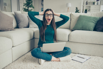 Obraz premium Amazed surprised funny funky screaming student holding laptop on legs sitting on floor touching head looking at camera