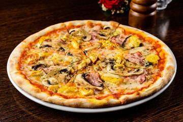Tasty warm pizza with bacon, mushrooms, cheese and onion on the table, close-up