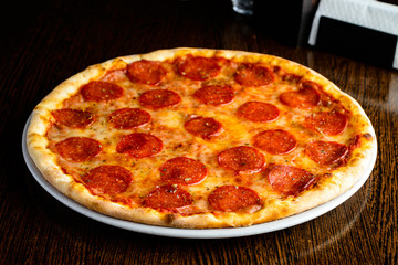 Delicious hot homemade Pepperoni pizza on the wooden table