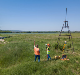 Two Land Surveyors Engineers are Working on the Green Field. Male and Female Surveyors on a...
