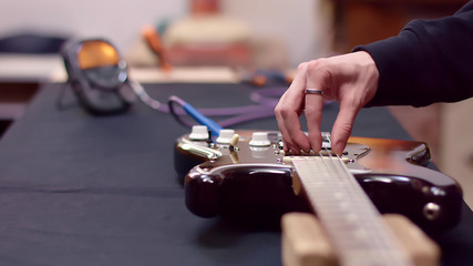 Guitarist tunes guitar with tuner