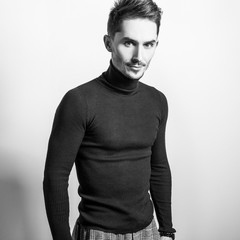 Handsome young elegant man in golf. Black-white studio photo.