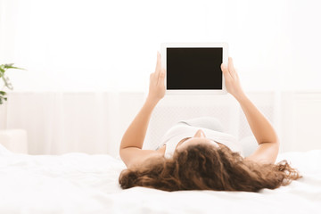 Young girl holding digital tablet with blank screen