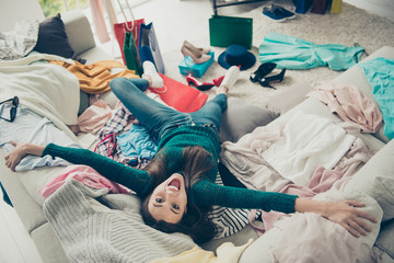 Upside down portrait of nice cute attractive pretty cheerful cheery girl student lying on divan among different things rejoicing having fun in light white interior room - obrazy, fototapety, plakaty