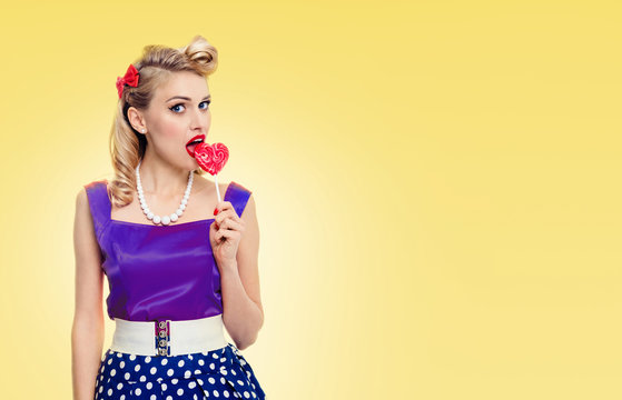 Woman eating lollipop, dressed in pinup style