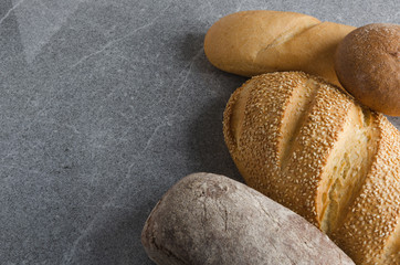 Assortment of delicious bread on gray stone table in the kitchen
