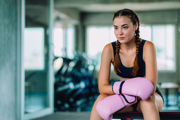 Fototapeta na wymiar Fit beautiful young woman muay thai boxer exercise class in a gym. Healthy, sport, lifestyle, Fitness, workout concept. With copy space.