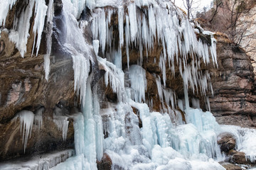 Large frozen icicles on site of waterfalls in mountainous area
