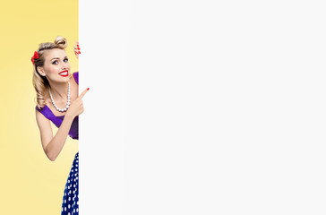 woman in pin-up style dress, showing blank signboard