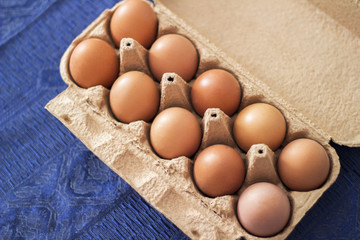 Overhead view of brown chicken eggs in an open egg carton. Fresh chicken eggs background.