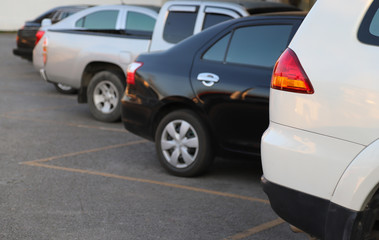 Fototapeta na wymiar Closeup of back or rear side of white car and other cars parking in parking area with natural background in twilight evening of sunny day. 